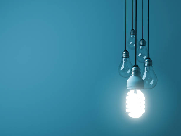 istock One hanging eco energy saving light bulb glowing and standing out from unlit incandescent bulbs on dark green pastel color background , leadership and different creative idea concept. 3D rendering 947418054