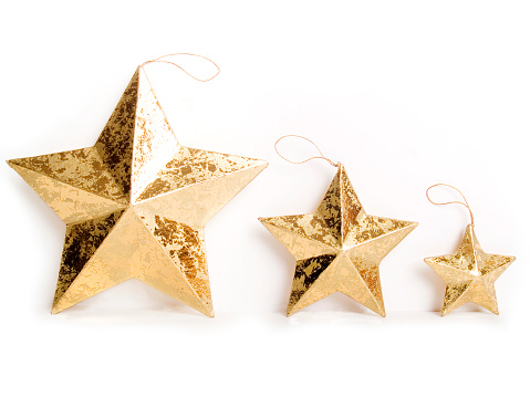 Three different sizes of the same ornament on white with a soft shadow beneath and behind each star; copy space 