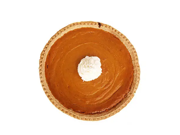 Whole pumpkin pie taken from directly above on a white background; whipped cream in center of pie; copy space 