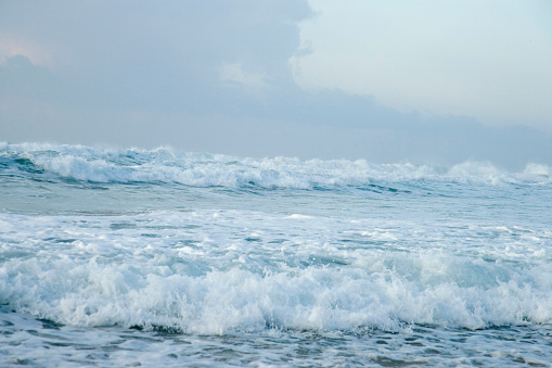 Frame half full of white-capped waves taken on a remote beach in Kauai where surfers play; copy space 