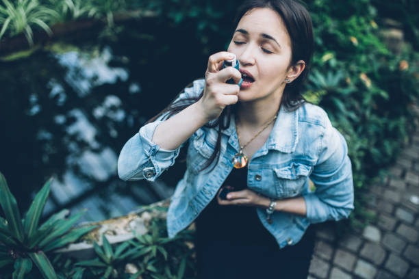 istock Pretty woman using her inhaler 947434600