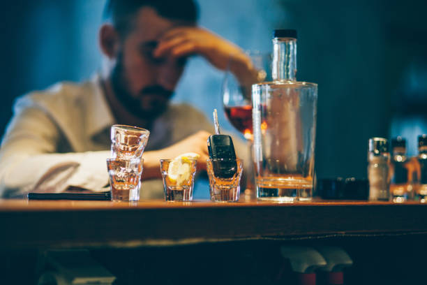 Drinking alone One man, sitting at the bar counter alone, he has drinking problems. alcohol abuse stock pictures, royalty-free photos & images