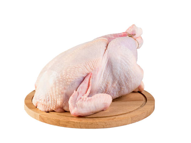 istock whole carcass of raw chicken on cutting Board, side view, isolated image on white background. 947437556