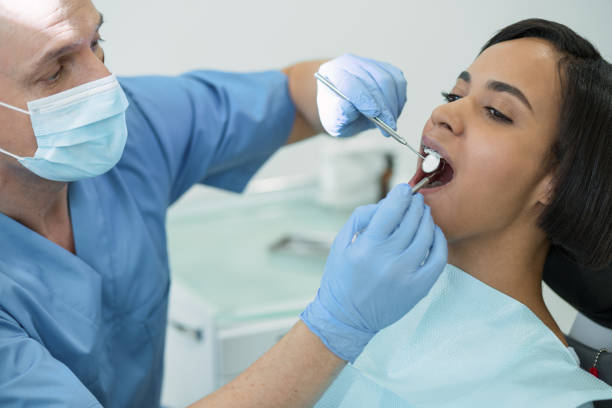 istock Successful male dentist examining his patients teeth 947443182