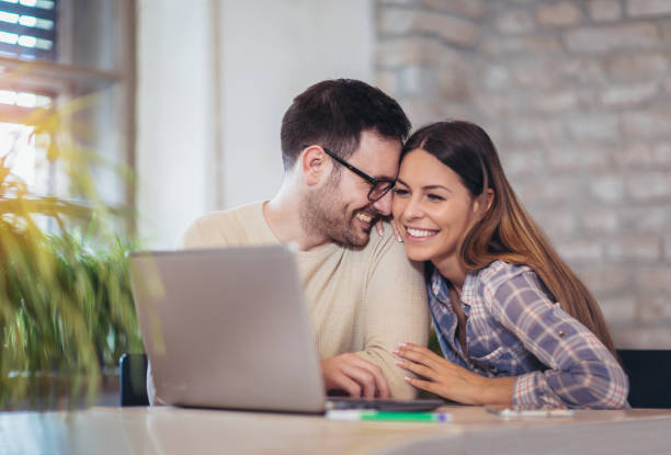 istock Young Couple Using Laptop On Desk At Home 947443370