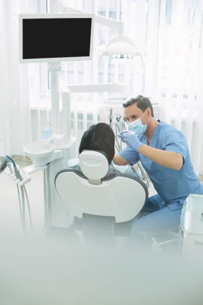 istock Young male dentist examining his patients teeth 947443644