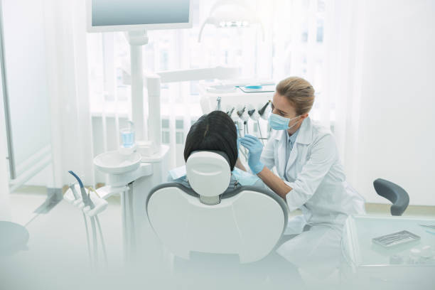 istock Concentrated female dentist examining her patients teeth 947444262