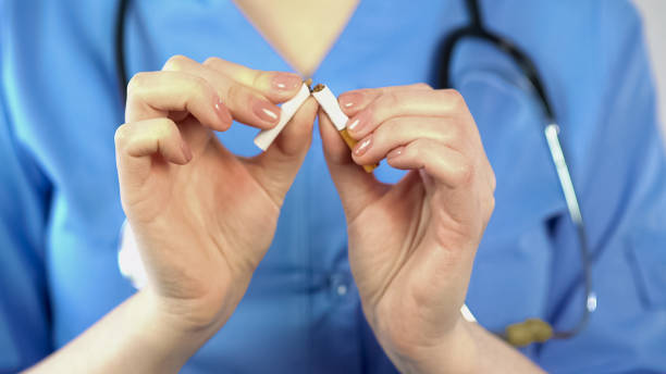 istock Doctor breaking cigarette, unhealthy smoking habit, harmful influence, addiction 947444468