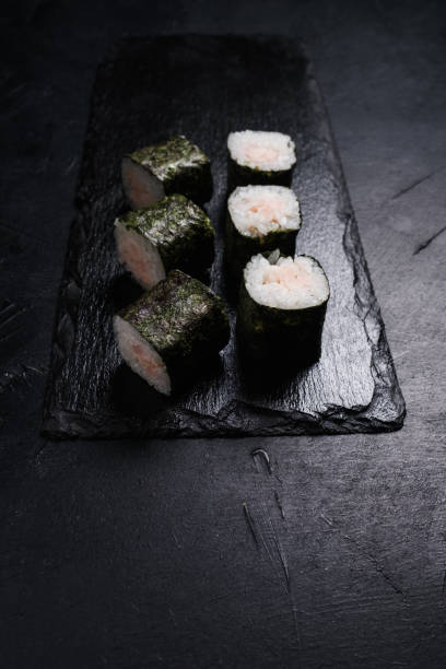 istock sushi salmon rolls dark background asian cuisine 947445556