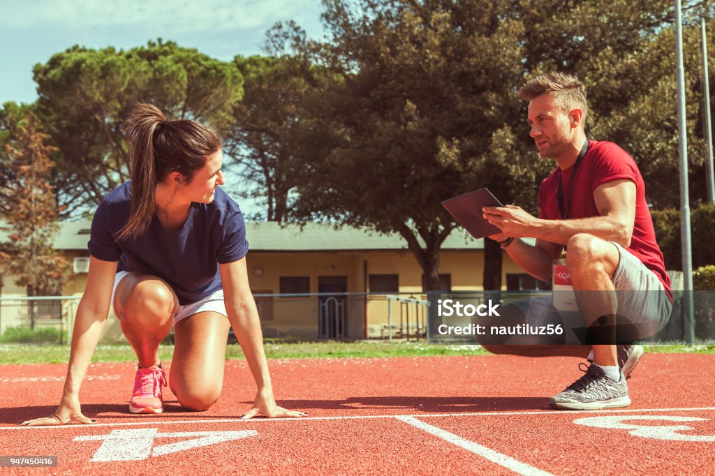 l’entraîneur fois et donne des conseils pour la balade à son jeune coureur - Photo de Entraîneur libre de droits