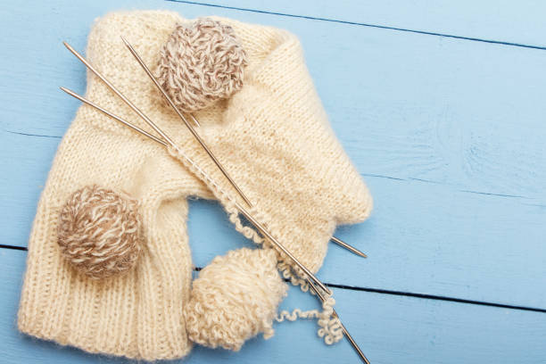 istock Homemade socks from sheep wool on wooden background. Copy space. Top view 947451944