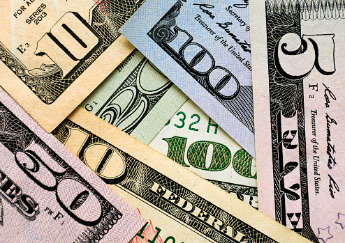 Close up of banknotes of American dollars of different denominations. Background image.