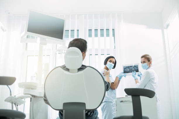istock Skilled dentists showing teeth on the screen 947460170