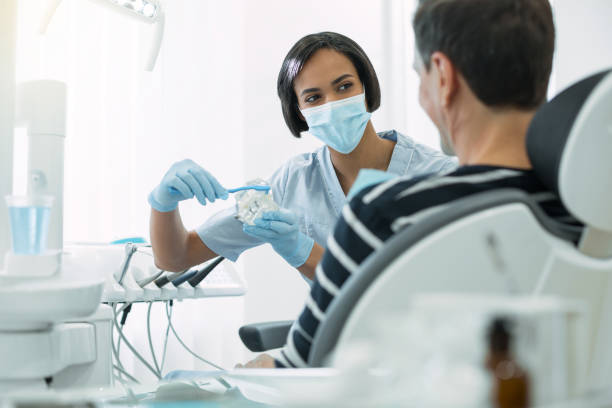 istock Inspired dentist showing how to brush teeth correctly 947460400