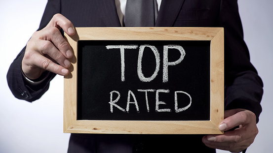 Top rated written on blackboard, business person holding sign, business concept, stock footage
