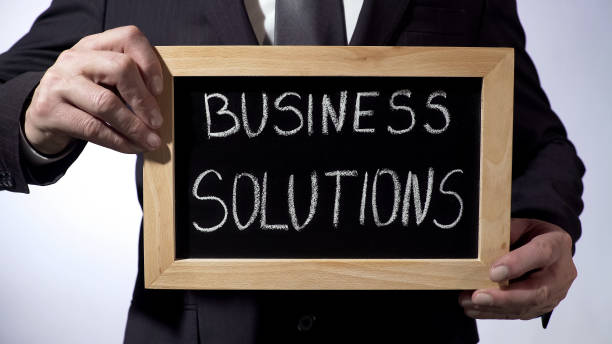 istock Business solutions written on blackboard, businessman holding sign, strategy 947471854