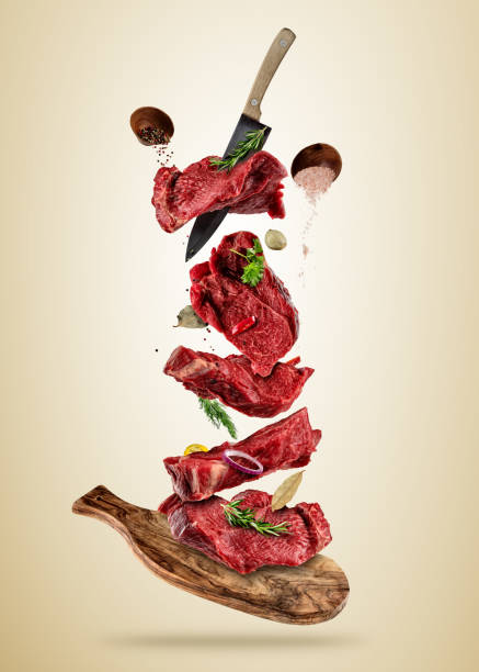 istock Flying pieces of raw beef steaks from cutting board 947472260