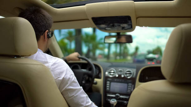 autista guida con sicurezza la sua auto, si tiene in contatto con il corteo attraverso le cuffie - car driving businessman hands free device foto e immagini stock