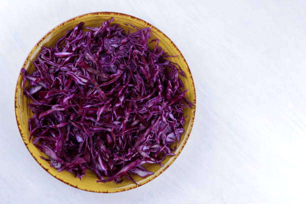 istock Chopped cabbage on white background, red cabbage on a yellow plate, copy space, top view, vegetarian food, fresh vegetables for salad, white background, minimalism, isolated 947483292