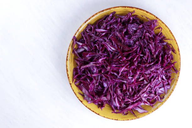 istock Chopped cabbage on white background, red cabbage on a yellow plate, copy space, top view, vegetarian food, fresh vegetables for salad, white background, minimalism, isolated 947483336