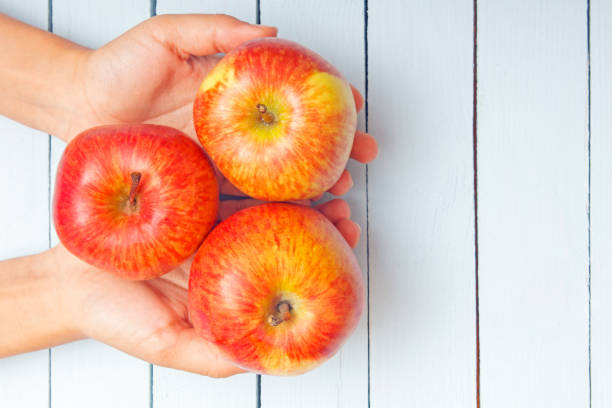 istock Presenting fresh natural organic fruit. Ripe apples on female hand. Top view 947483712