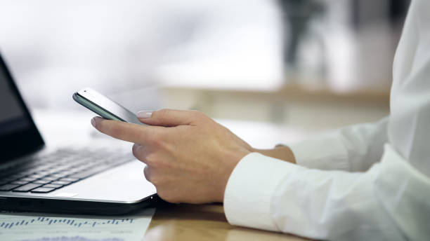 istock Female hands checking message on smartphone, little break at workplace, closeup 947484502
