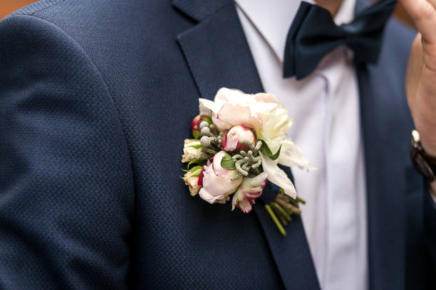 istock white rose boutonniere on groom's suit 947489362