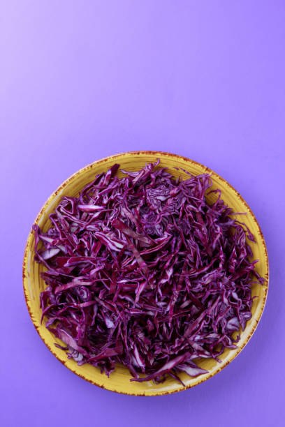 istock Chopped cabbage on a violet background, red cabbage on a yellow plate, copy space, top view, vegetarian food, fresh vegetables for salad, ultraviolet background, minimalism 947491666