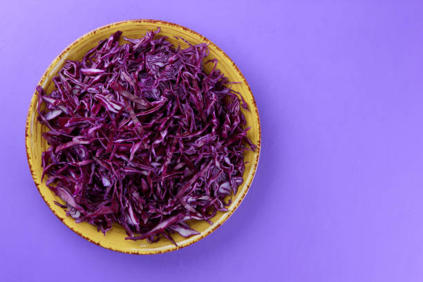 istock Chopped cabbage on a violet background, red cabbage on a yellow plate, copy space, top view, vegetarian food, fresh vegetables for salad, ultraviolet background, minimalism 947491706