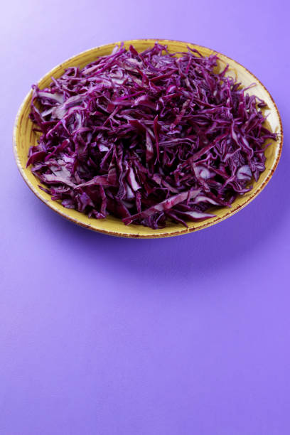 istock Chopped cabbage on a violet background, red cabbage on a yellow plate, copy space, top view, vegetarian food, fresh vegetables for salad, ultraviolet background, minimalism 947491798