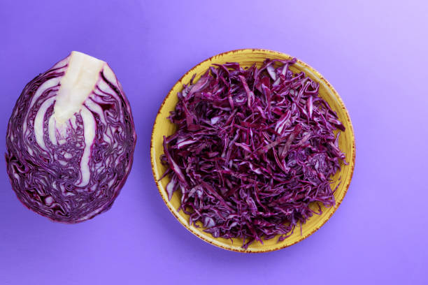 istock Chopped cabbage on a violet background, red cabbage on a yellow plate, copy space, top view, vegetarian food, fresh vegetables for salad, ultraviolet background, minimalism 947491874