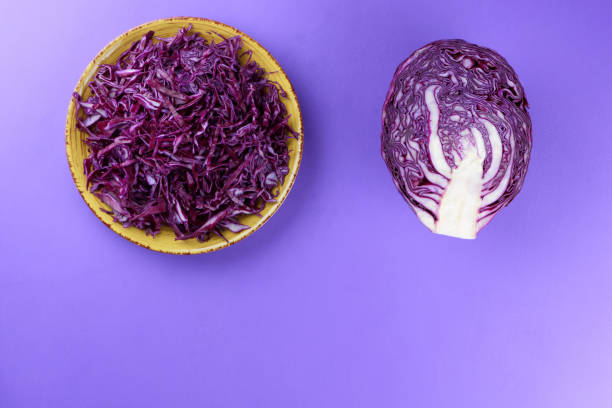 istock Chopped cabbage on a violet background, red cabbage on a yellow plate, copy space, top view, vegetarian food, fresh vegetables for salad, ultraviolet background, minimalism 947491932