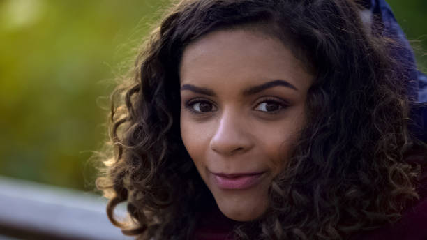 istock Beautiful biracial woman posing for camera and smiling sincerely, face close-up 947497384