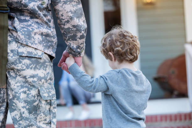 istock Soldier holds hands with young son 947502850