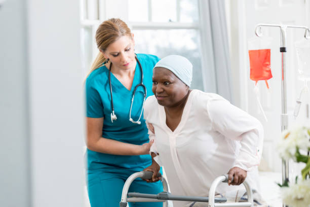 istock Female nurse helps senior patient walk 947503098