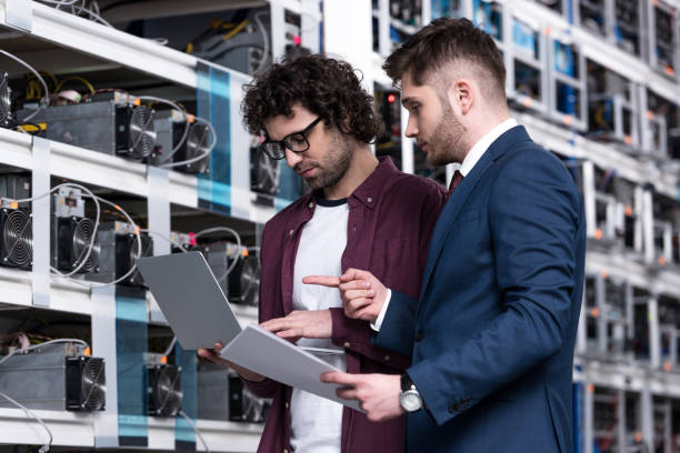 istock businessman and computer engineer working with laptop together at bitcoin mining farm 947507022