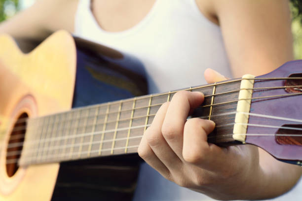 istock Woman playing guitar at the park. 947507520