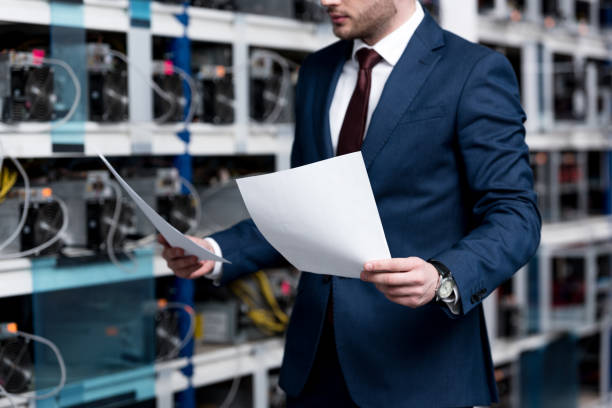 istock handsome young businessman reading documents at cryptocurrency mining farm 947507686