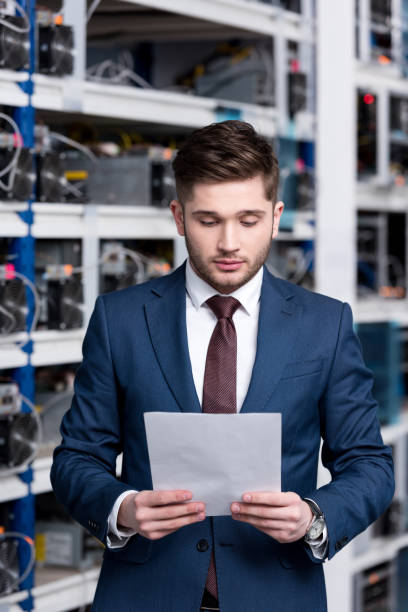 istock serious young businessman reading business document at cryptocurrency mining farm 947508482