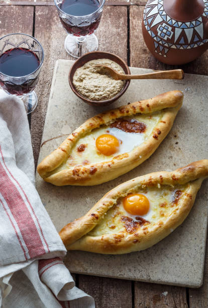 istock Ajarian khachapuri cheese bread with egg yolk, georgian breakfast, rustic style. 947512922