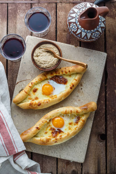 istock Ajarian khachapuri cheese bread with egg yolk, georgian breakfast, rustic style. 947515094