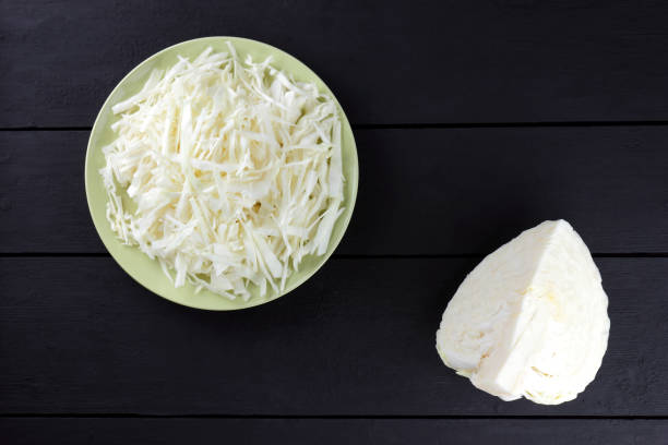 istock Chopped cabbage on a black background, white cabbage on a green plate, copy space, top view, vegetarian food, fresh vegetables on dark boards, black background, minimalism 947515204
