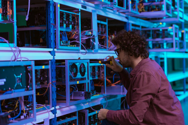 istock young computer engineer repairing at cryptocurrency mining farm with screwdriver 947517266