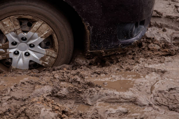 o carro está preso em uma estrada ruim na lama - mud car wet horizontal - fotografias e filmes do acervo
