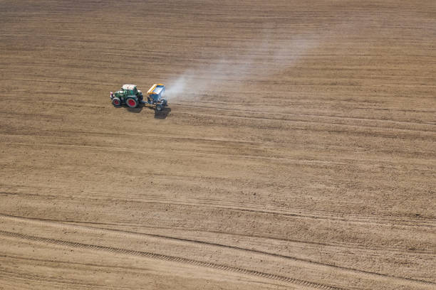istock Tractor fertilizing field, Aerial View. Tractor spreading artificial fertilizers. 947526454