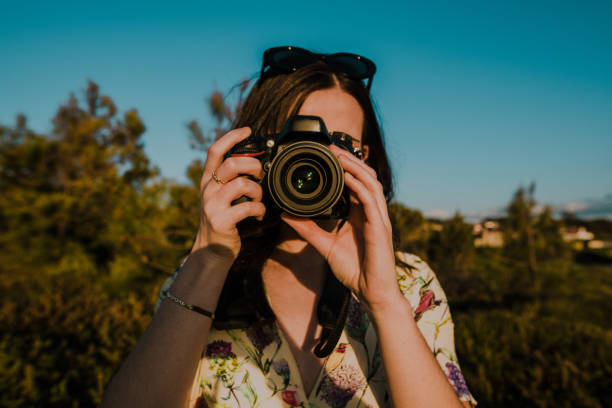 istock Young woman taking a picture with a DSLR camera 947527234