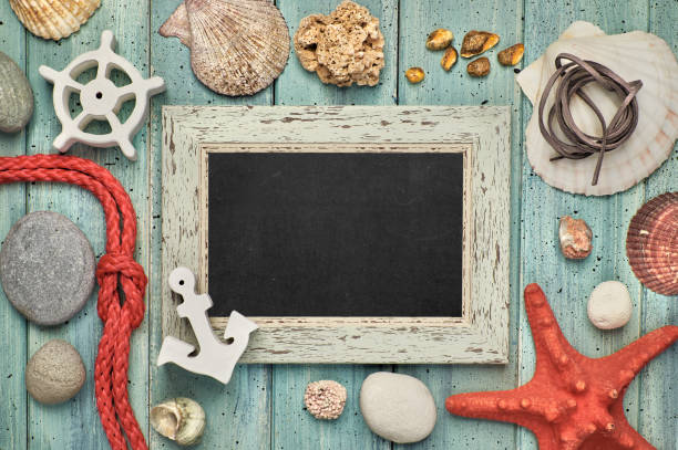 istock Blank blackboard with sea shells, rope, anchor and star fish on light wood, space 947528096