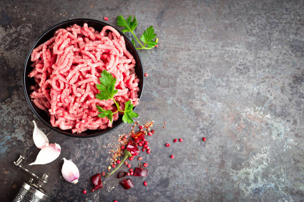 istock Raw ground beef meat with ingredients for cooking. Fresh minced meat 947536646