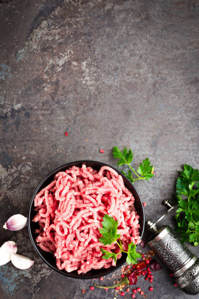 istock Raw ground beef meat with ingredients for cooking. Fresh minced meat 947536796