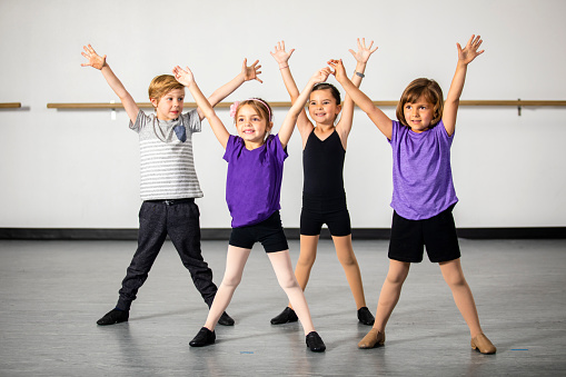 A cute group of children practicing musical theater in a dance studio